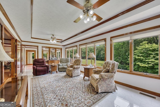 living area with visible vents, a textured ceiling, a tray ceiling, and a wealth of natural light