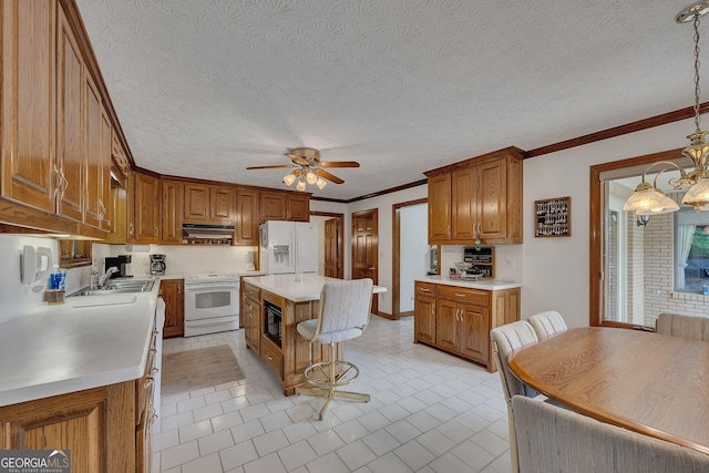 kitchen with brown cabinetry, light countertops, a sink, and white appliances