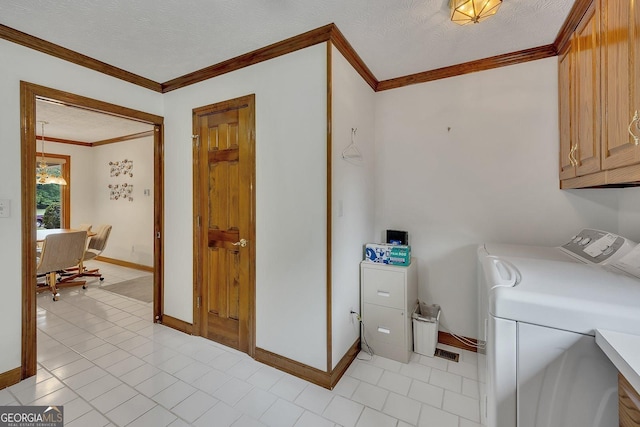 laundry room featuring a textured ceiling, crown molding, cabinet space, baseboards, and washer and dryer