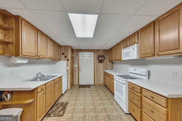 kitchen featuring a sink, open shelves, a paneled ceiling, and white appliances