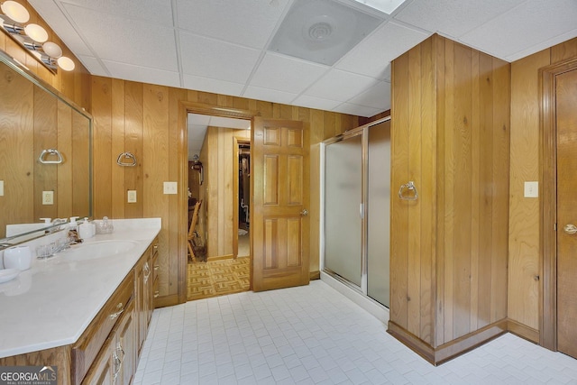 bathroom with vanity, wood walls, and a shower stall