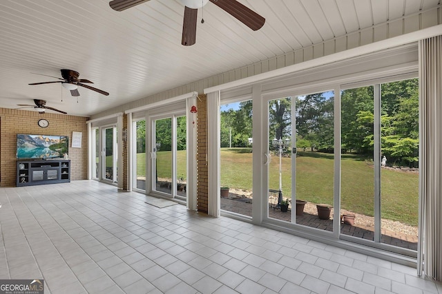 unfurnished sunroom with ceiling fan