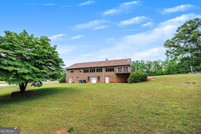 rear view of property featuring a lawn and brick siding