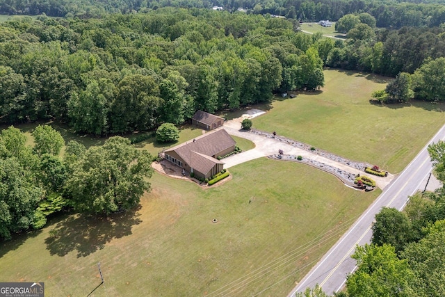 birds eye view of property featuring a view of trees