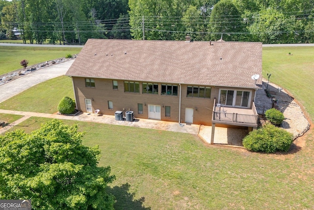 back of property featuring a yard, cooling unit, and roof with shingles