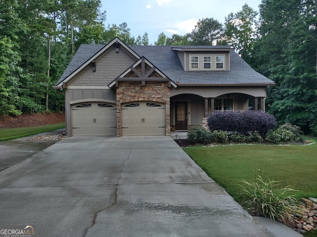 57 Deer Creek Run, Moreland, GA 30259 - craftsman-style home featuring driveway, a front yard, an attached garage, a shingled roof, and stone siding