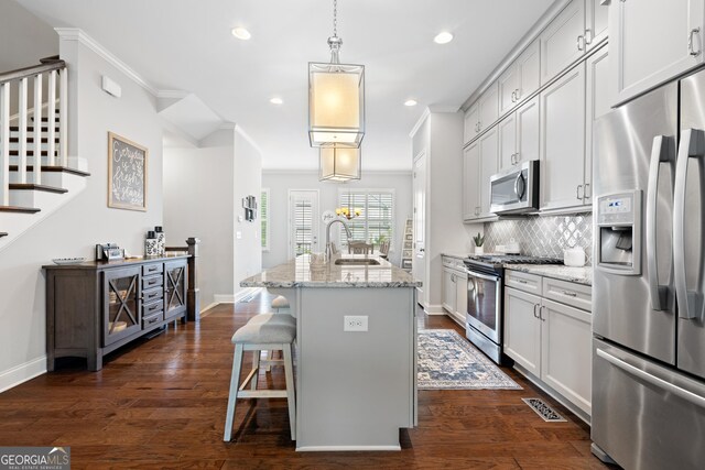 10200 Windalier Way, Roswell, GA 30076 - kitchen with an island with sink, tasteful backsplash, light stone counters, a sink, and stainless steel appliances