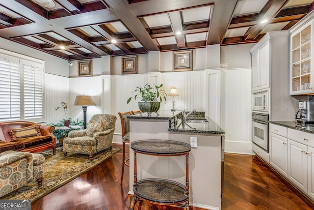 1717 N Decatur Rd NE Unit 214, Atlanta, GA 30307 - kitchen with beamed ceiling, stainless steel oven, and dark wood-style floors