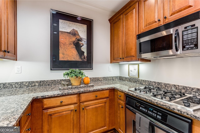 1717 N Decatur Rd NE Unit 214, Atlanta, GA 30307 - kitchen featuring light stone counters, stainless steel appliances, and brown cabinets