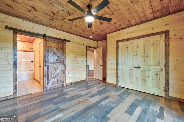 171 Antler Way, Morganton, GA 30560 - unfurnished bedroom featuring a barn door, wood finished floors, wooden walls, wooden ceiling, and connected bathroom