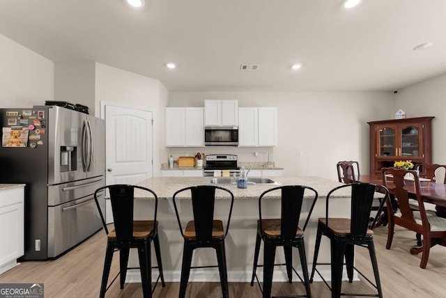 352 Walnut Grove Way, Pendergrass, GA 30567 - kitchen with stainless steel appliances, white cabinets, an island with sink, light wood finished floors, and recessed lighting