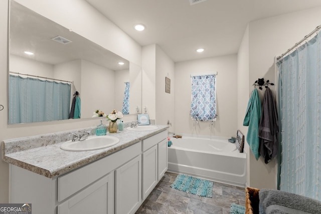 352 Walnut Grove Way, Pendergrass, GA 30567 - bathroom featuring a garden tub, double vanity, recessed lighting, and stone finish floors