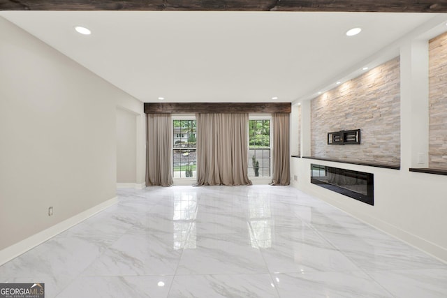 unfurnished living room with recessed lighting, baseboards, a large fireplace, and marble finish floor