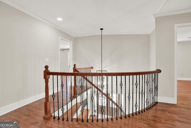 corridor with baseboards, an upstairs landing, ornamental molding, and wood finished floors