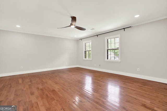 unfurnished room with baseboards, a ceiling fan, wood finished floors, and ornamental molding