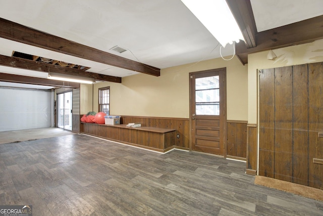 interior space with wood finished floors, wainscoting, beam ceiling, and a healthy amount of sunlight