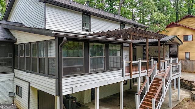 view of side of property featuring a pergola, a patio area, and a sunroom