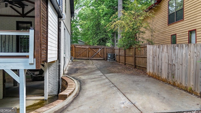view of property exterior with fence, a gate, and a patio