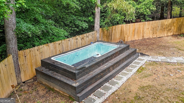 view of pool featuring a hot tub and a fenced backyard