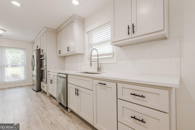 9985 Lake Forest Way, Roswell, GA 30076 - kitchen with decorative backsplash, light wood-style floors, recessed lighting, a sink, and stainless steel appliances