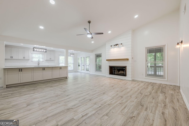 9985 Lake Forest Way, Roswell, GA 30076 - unfurnished living room with light wood finished floors, ceiling fan with notable chandelier, and a healthy amount of sunlight