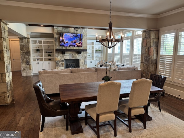 2220 Cambridge Hill Ct, Dacula, GA 30019 - dining room with crown molding, a chandelier, dark wood-style floors, a fireplace, and built in shelves