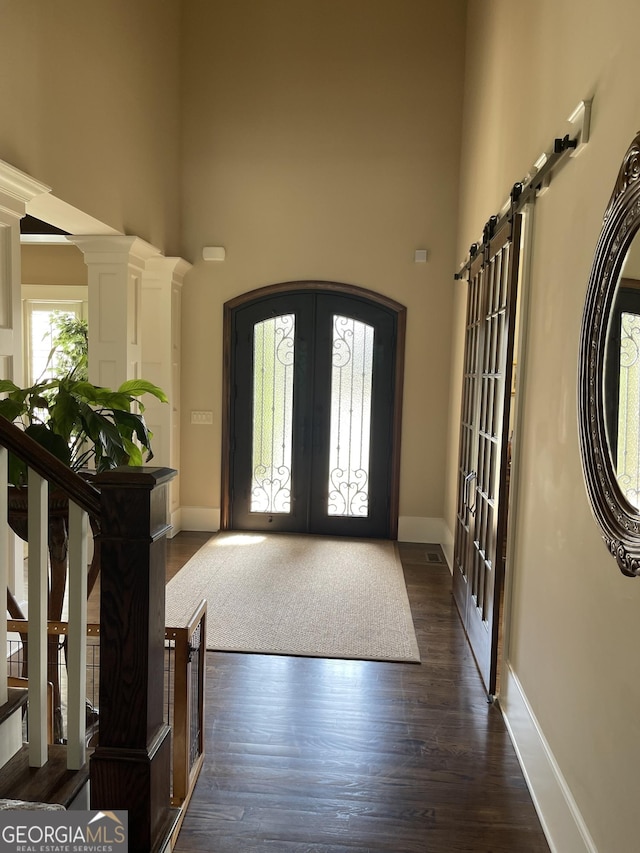 2220 Cambridge Hill Ct, Dacula, GA 30019 - foyer entrance with french doors, a towering ceiling, baseboards, dark wood finished floors, and arched walkways
