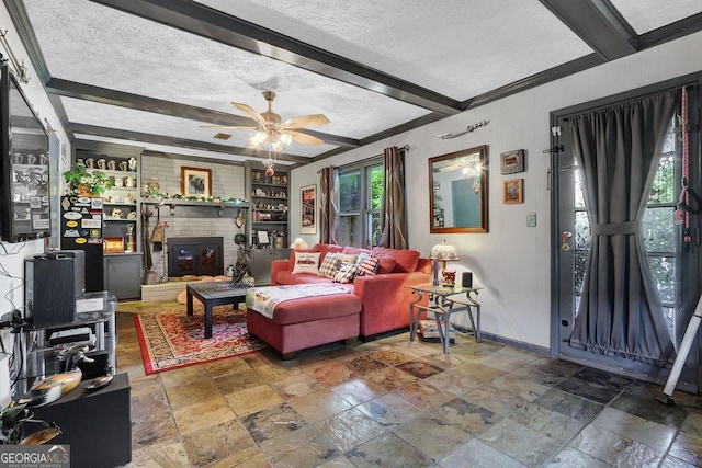 living area with baseboards, stone tile floors, a ceiling fan, and beam ceiling