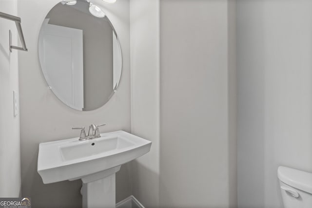 half bathroom featuring a sink and toilet