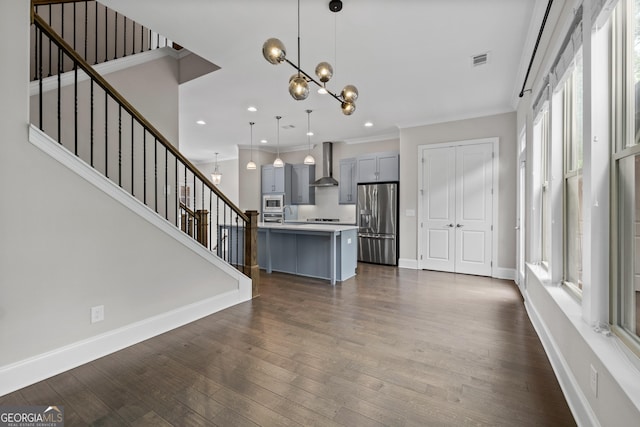 unfurnished living room with dark wood-style flooring, visible vents, crown molding, stairway, and an inviting chandelier