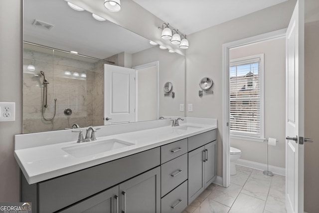 bathroom with visible vents, a sink, marble finish floor, and a tile shower