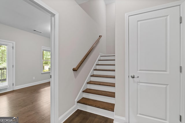 staircase featuring visible vents, baseboards, and wood finished floors