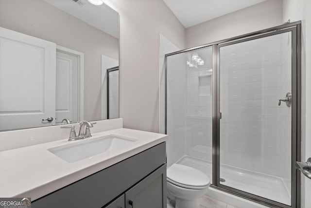bathroom with vanity, a stall shower, and toilet