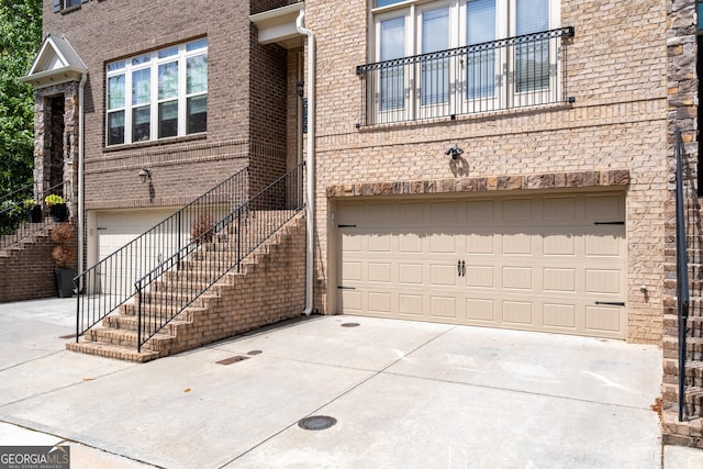 exterior space featuring concrete driveway, brick siding, and an attached garage