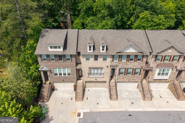 view of front of home featuring an attached garage, driveway, and stairs