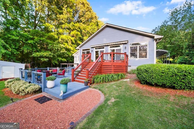 view of front of house featuring a deck, crawl space, a front yard, stairway, and an outbuilding