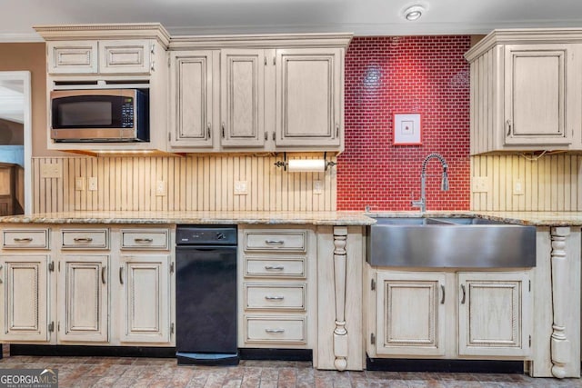 kitchen featuring a sink, stainless steel microwave, cream cabinetry, and ornamental molding