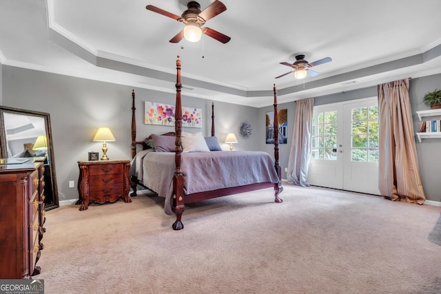 bedroom with a tray ceiling, light colored carpet, ornamental molding, and access to exterior