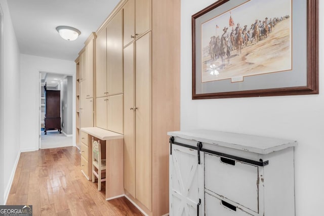corridor featuring baseboards and light wood-style floors