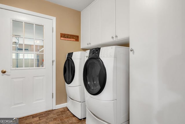 laundry room featuring baseboards, cabinet space, and washer and clothes dryer