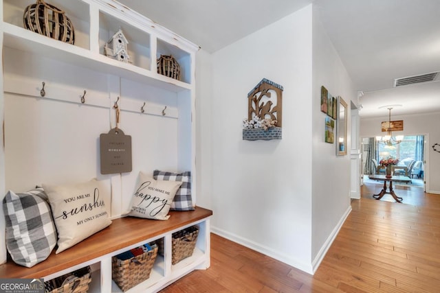 mudroom with baseboards, visible vents, light wood-style flooring, and a chandelier