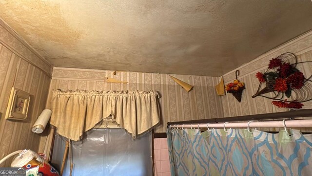 tiled bedroom with a textured ceiling and wallpapered walls