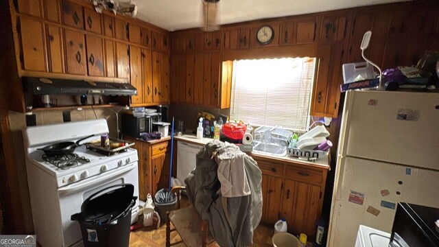 kitchen with light countertops, ventilation hood, brown cabinetry, and white appliances