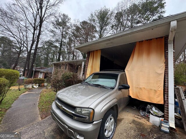 view of parking / parking lot featuring an attached carport