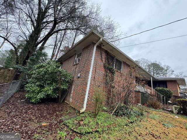view of home's exterior featuring brick siding and fence