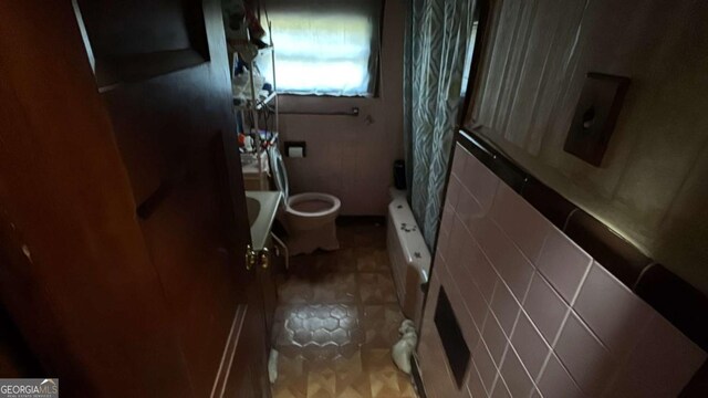 full bath featuring toilet and shower / tub combo with curtain