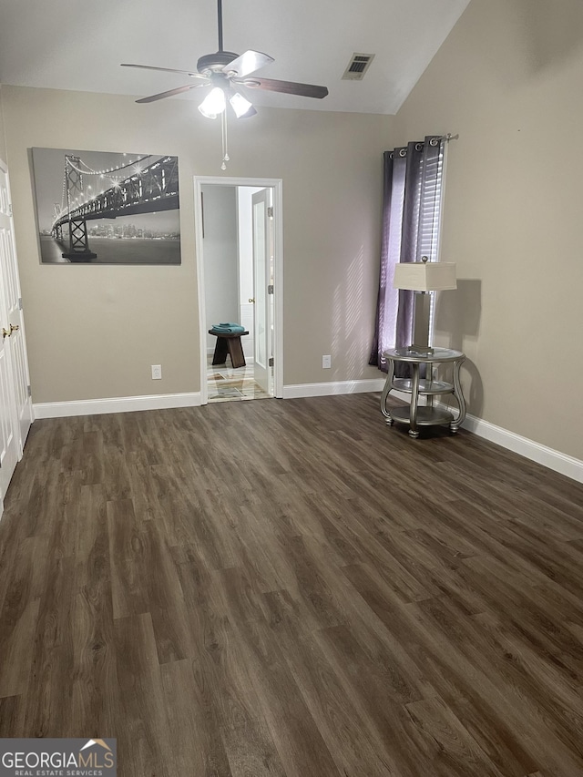 unfurnished bedroom with ceiling fan, visible vents, vaulted ceiling, baseboards, and dark wood-type flooring
