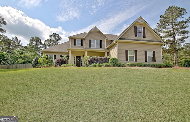 craftsman house with a front lawn and fence