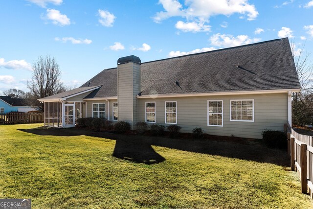 17 Castleview Ct, Jefferson, GA 30549 - back of house featuring fence, roof with shingles, a sunroom, a chimney, and a lawn