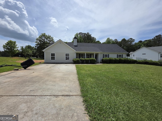 single story home with a chimney, driveway, and a front yard